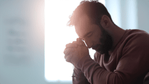 A man closeup shot praying holding her hands